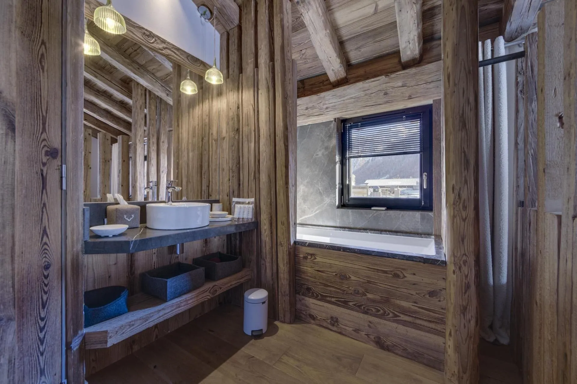 Bathroom with reclaimed wood paneling, stone vanity, and soaking tub