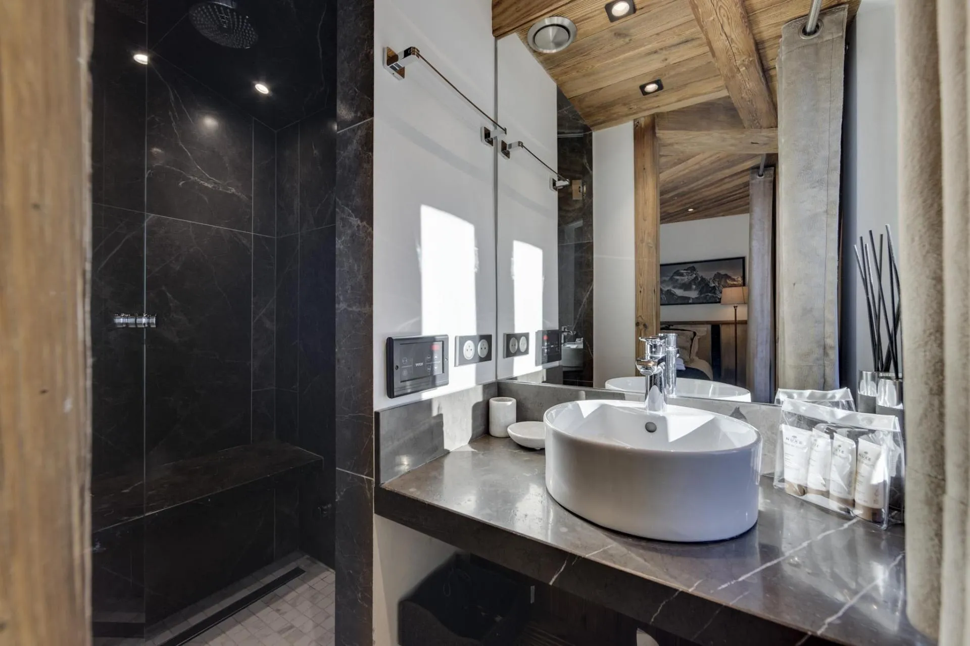 Bathroom featuring marble walk-in shower with rainfall head and built-in bench