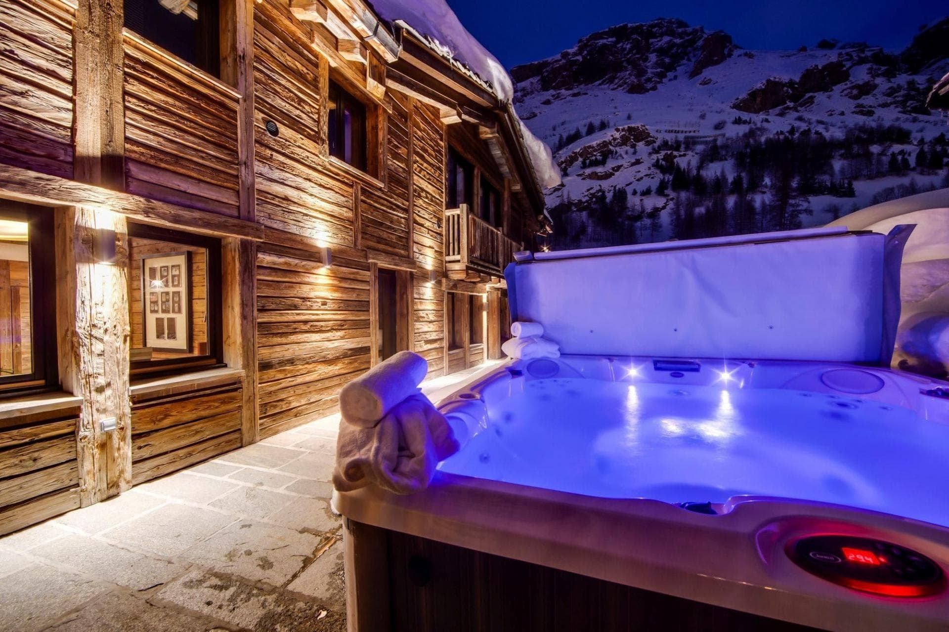 Outdoor hot tub with mountain views and adjacent timber chalet