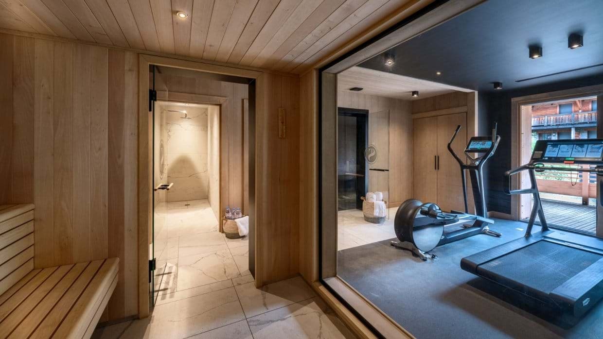 Private wellness suite with cedar sauna, walk-in shower, and gym equipment