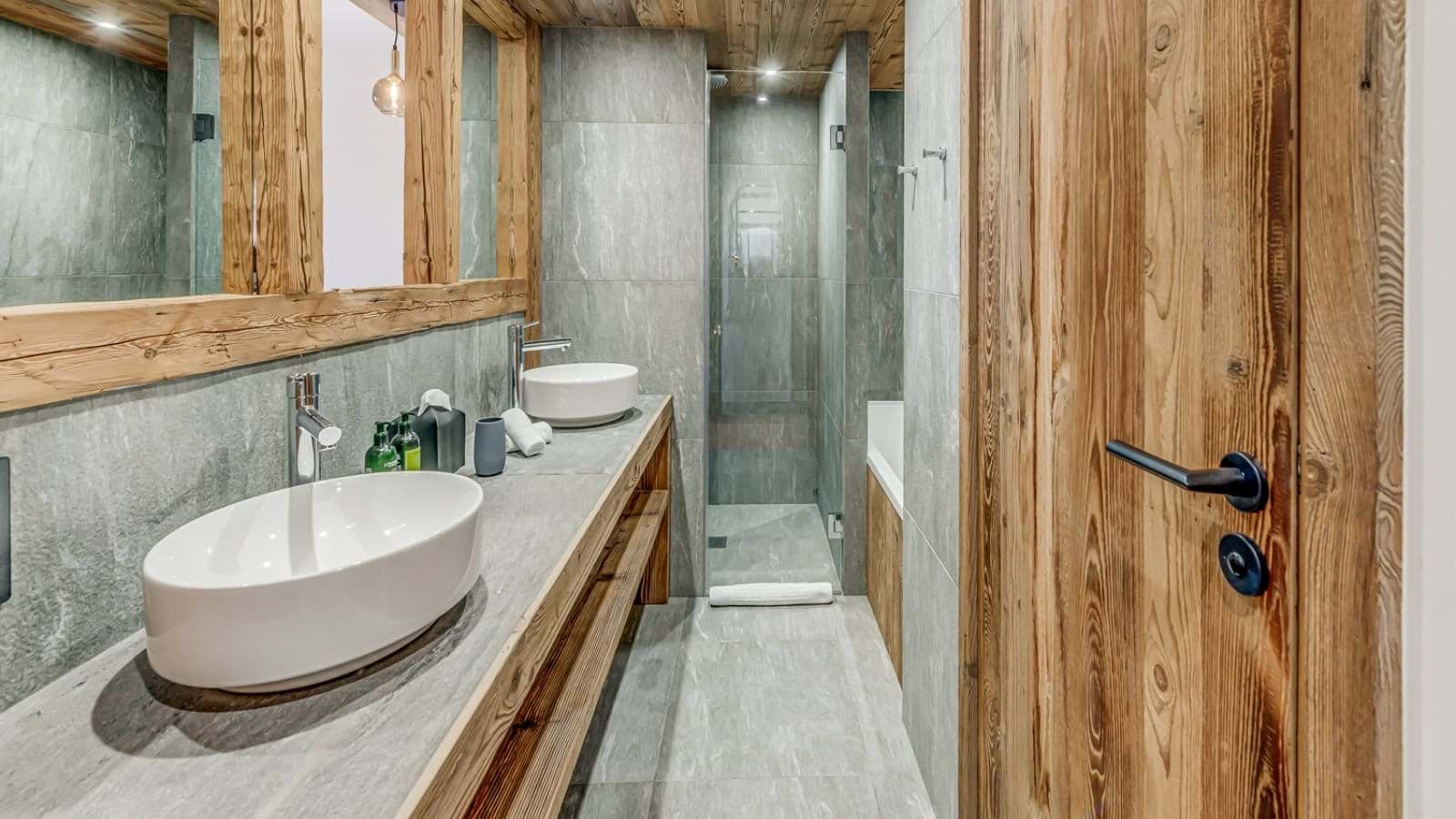 Bathroom with dual vessel sinks, walk-in shower, and separate soaking tub