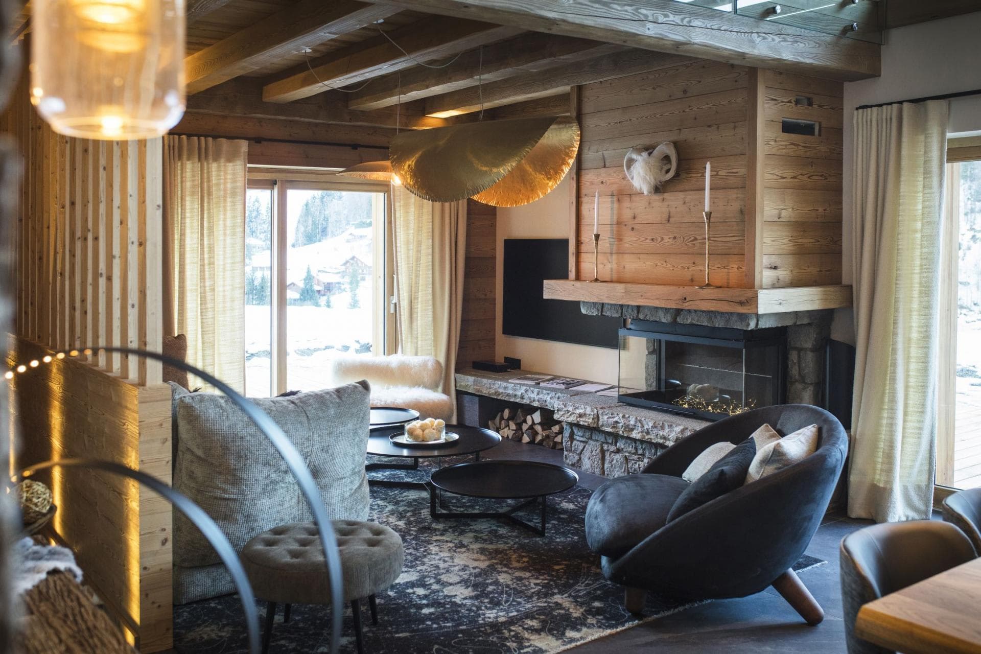 Living area with wood-burning fireplace and floor-to-ceiling windows showing ski mountain views