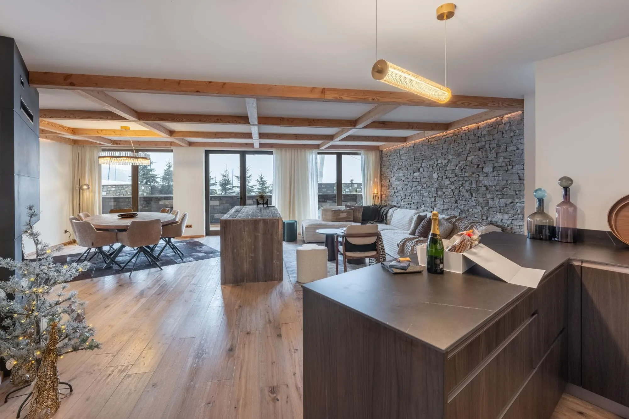 Open-plan living and dining area with stone feature wall