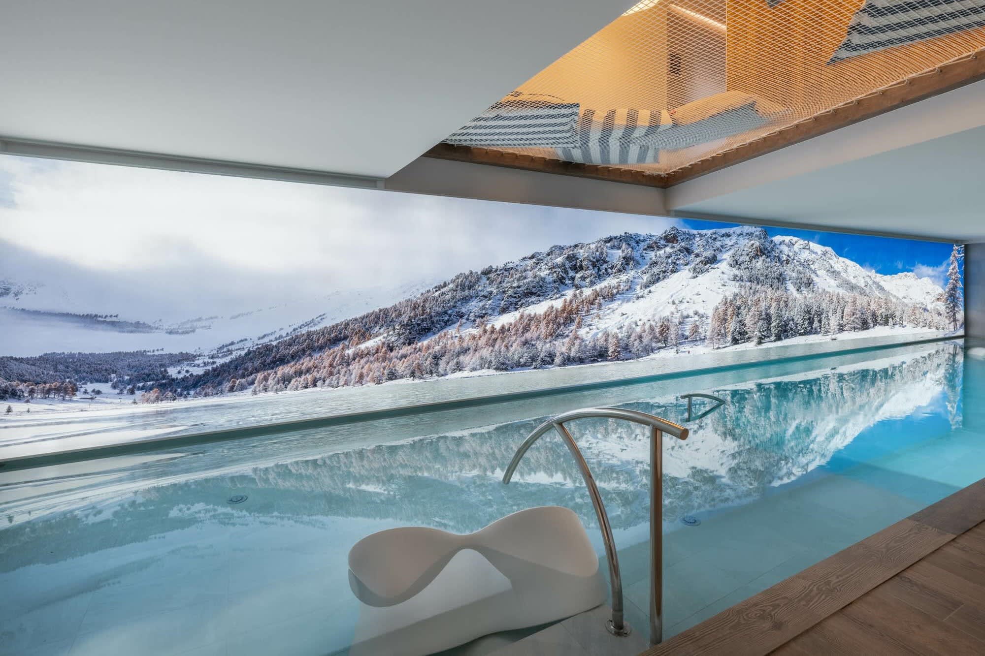 Indoor infinity pool with mountain views and overhead lounge netting