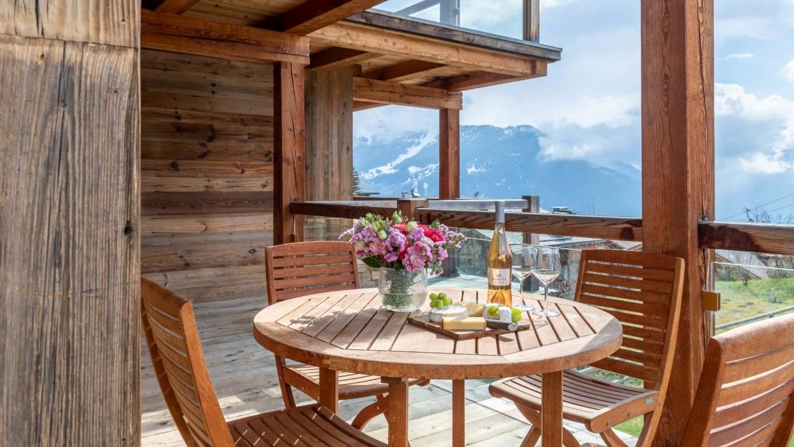 Covered wooden balcony with seating for 4 and mountain views