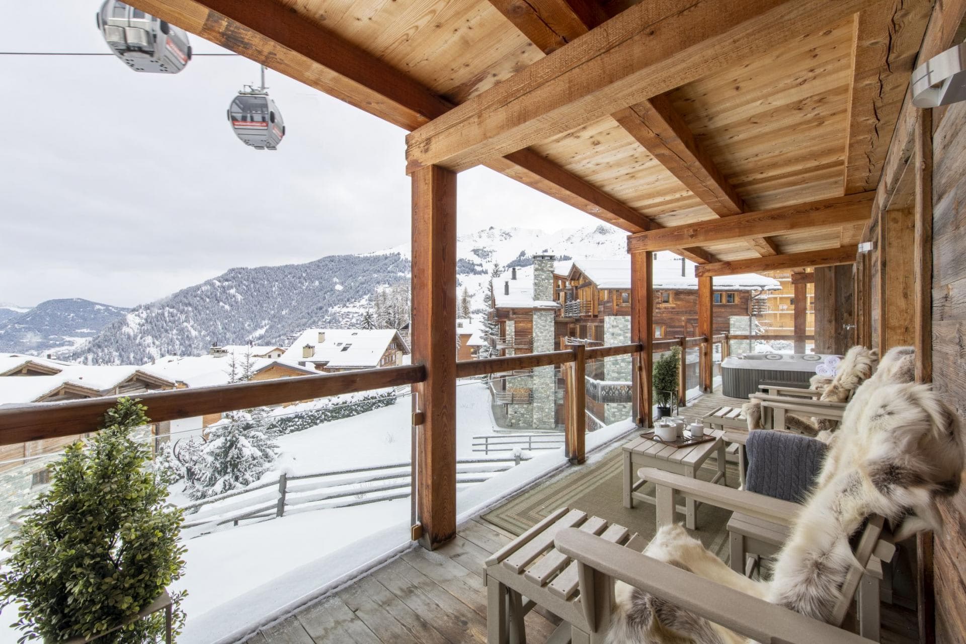 Covered timber balcony with hot tub and ski lift views