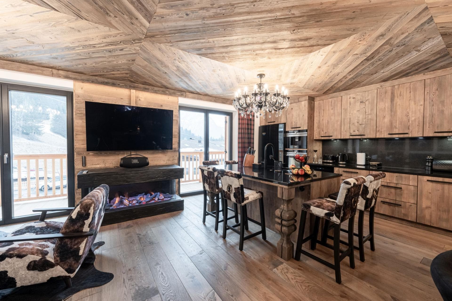 Open-plan kitchen and lounge with electric fireplace and island seating for 4