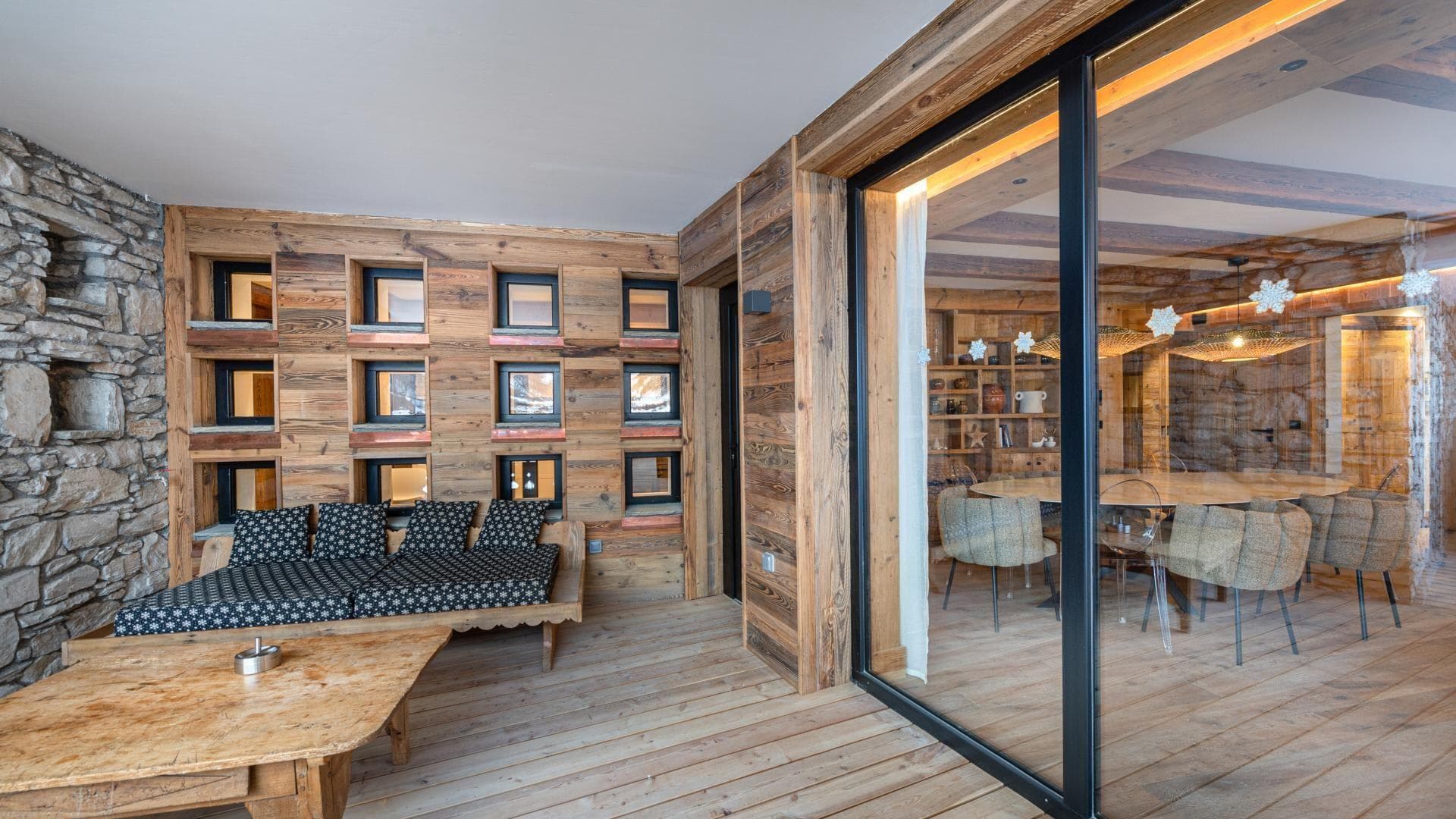 Covered terrace with built-in daybed and view into formal dining area