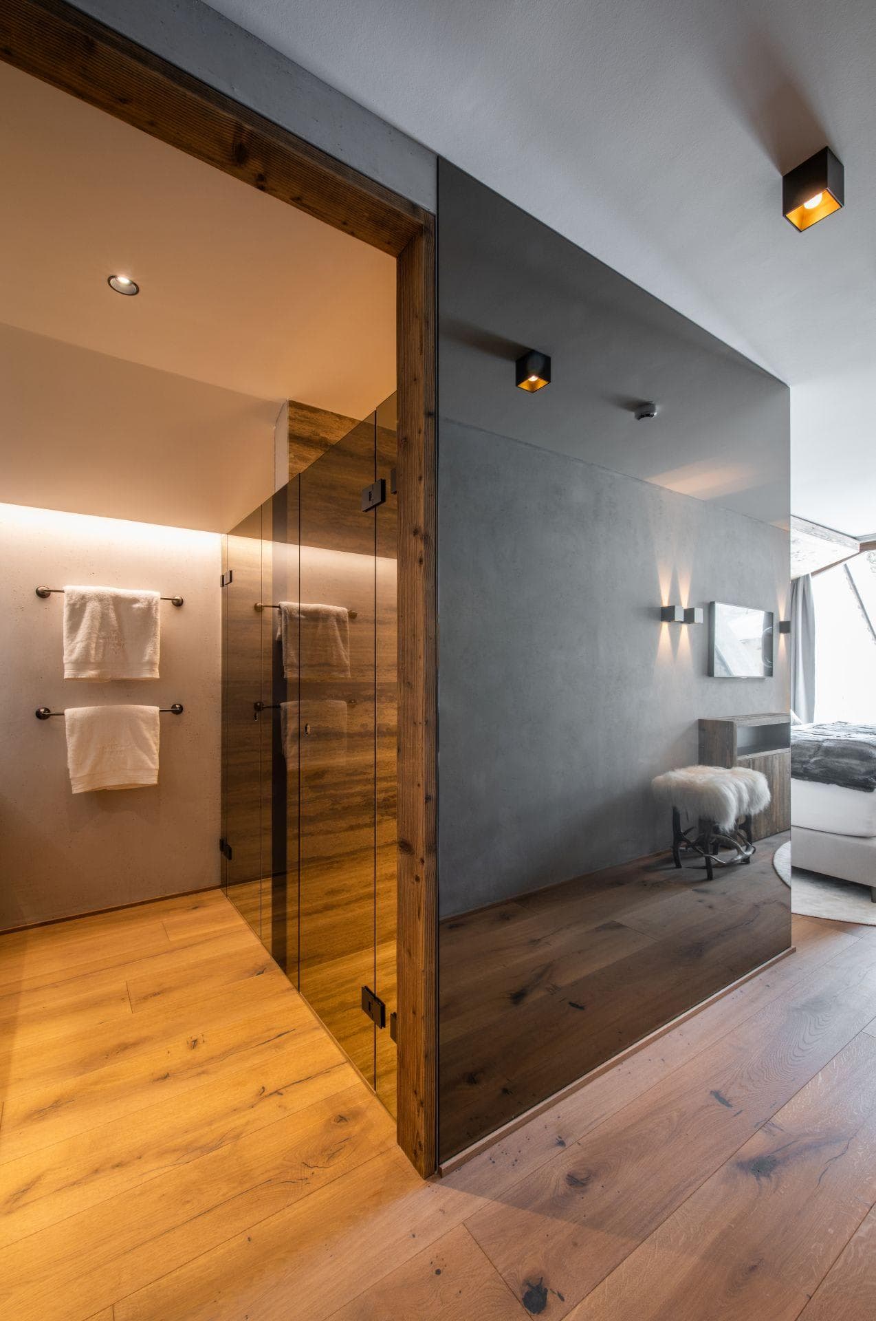Walk-in shower with glass enclosure and wood-framed entrance