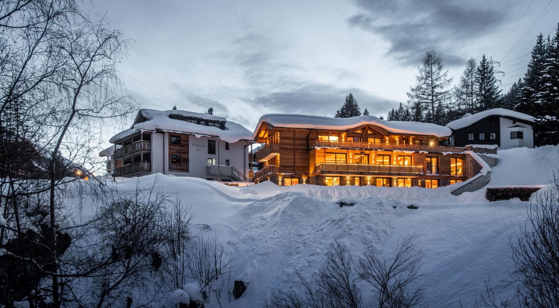 Wooden chalet exterior with multiple private balconies and snow-covered grounds
