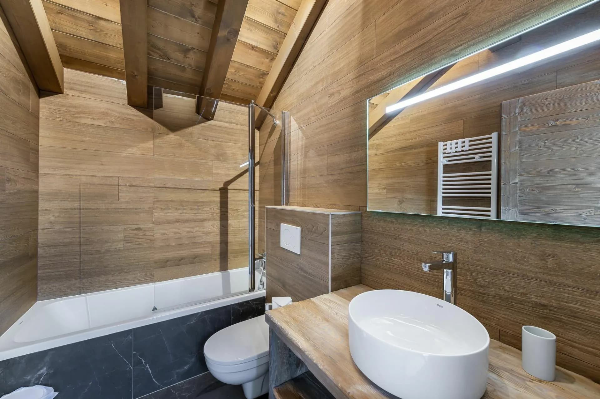Upper-level bathroom with bathtub, basin and toilet
