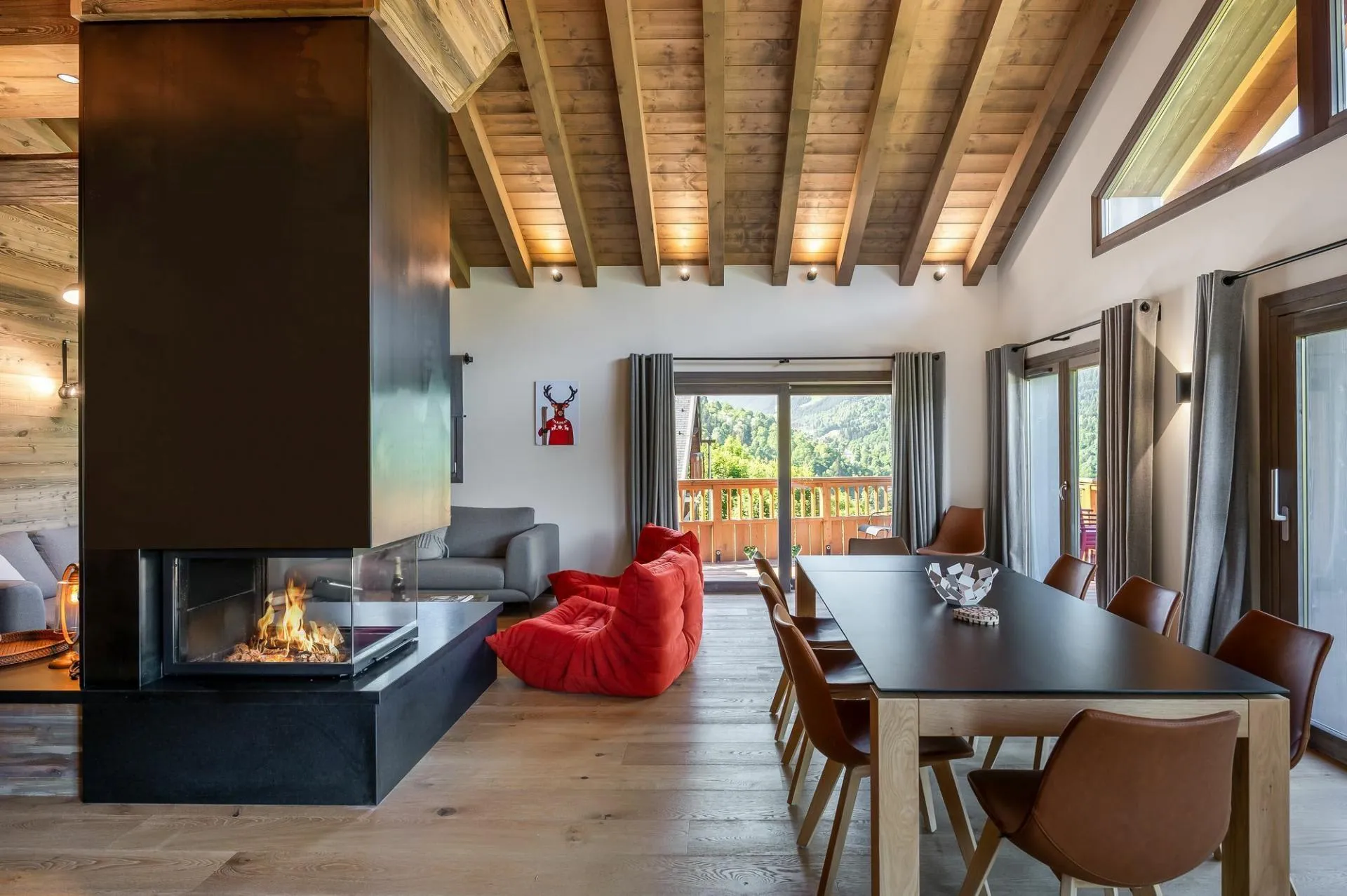 Bright dining and living area with balcony access and central fireplace