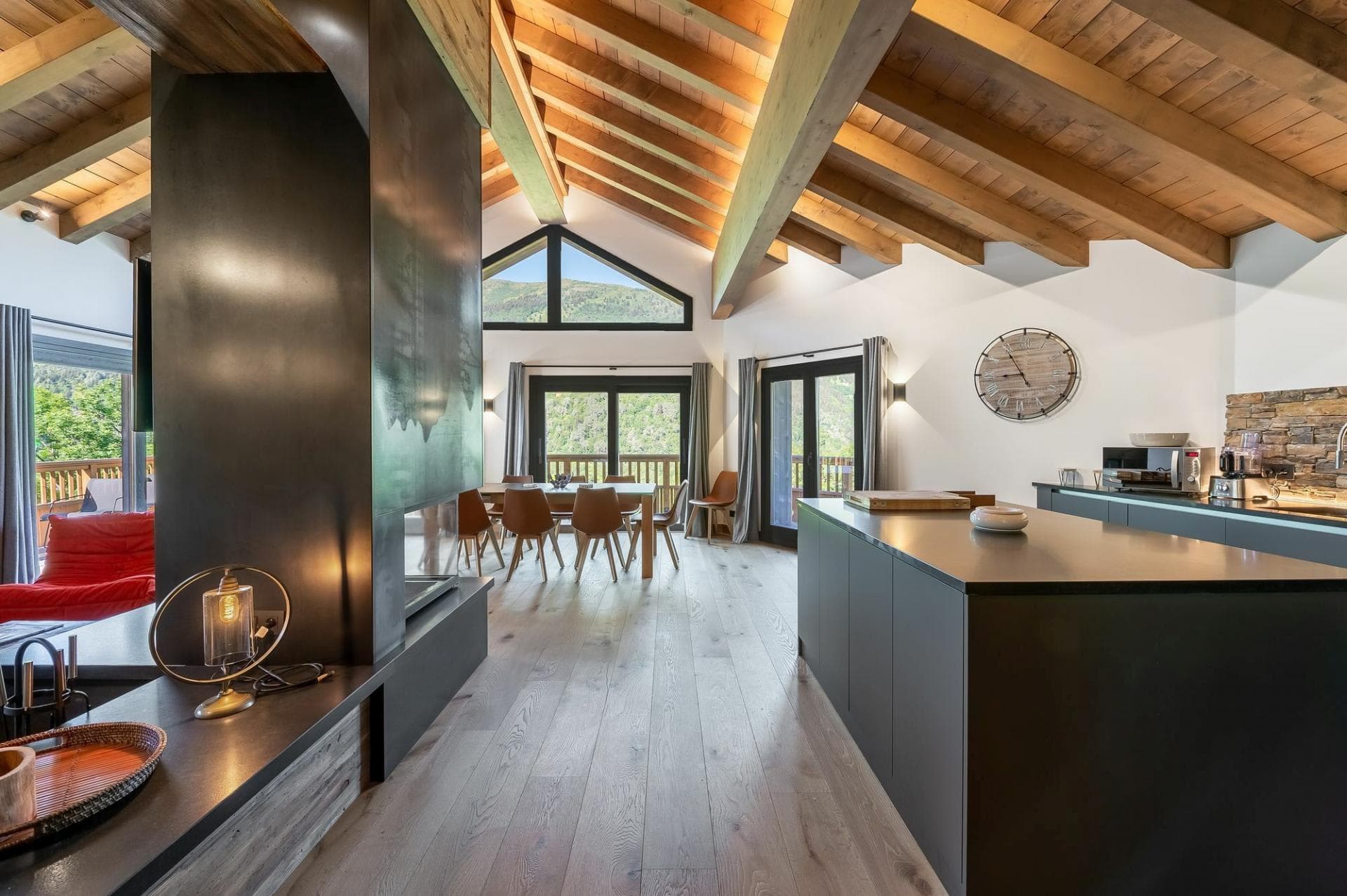 Open-plan living area with vaulted beam ceilings and mountain-view dining