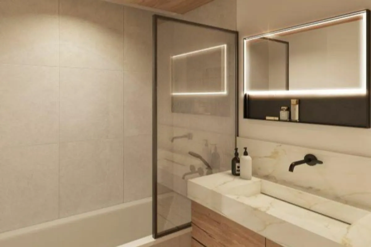 Bathroom with bath, glass screen and illuminated mirror
