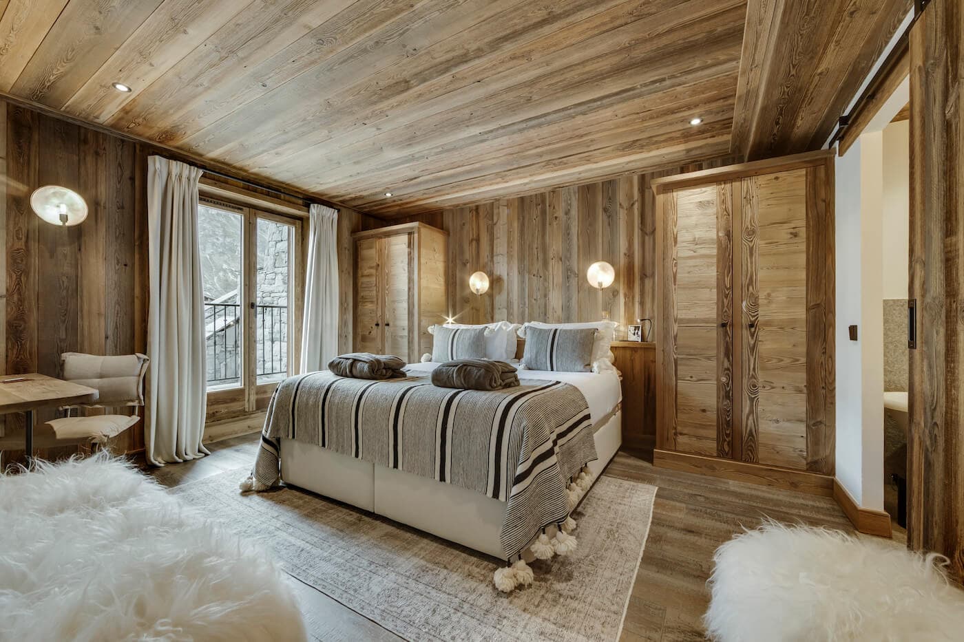 Wood-paneled bedroom with king bed and ensuite bathroom access