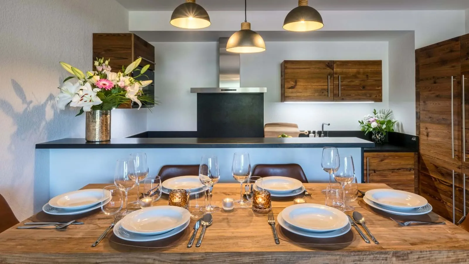 Pull-out dining table with six place settings beside the kitchen
