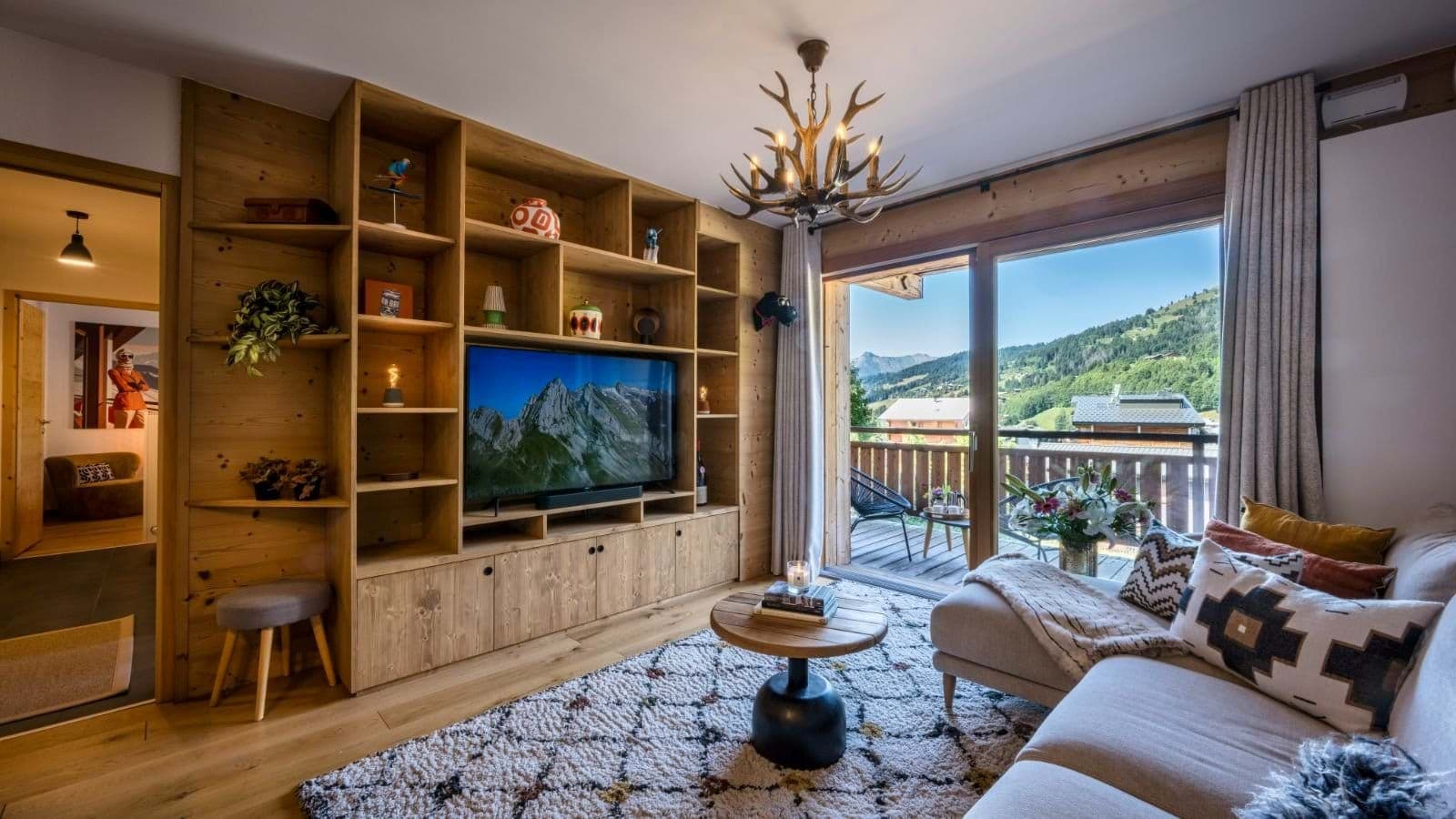 Living area with antler chandelier, smart TV, and mountain-view balcony