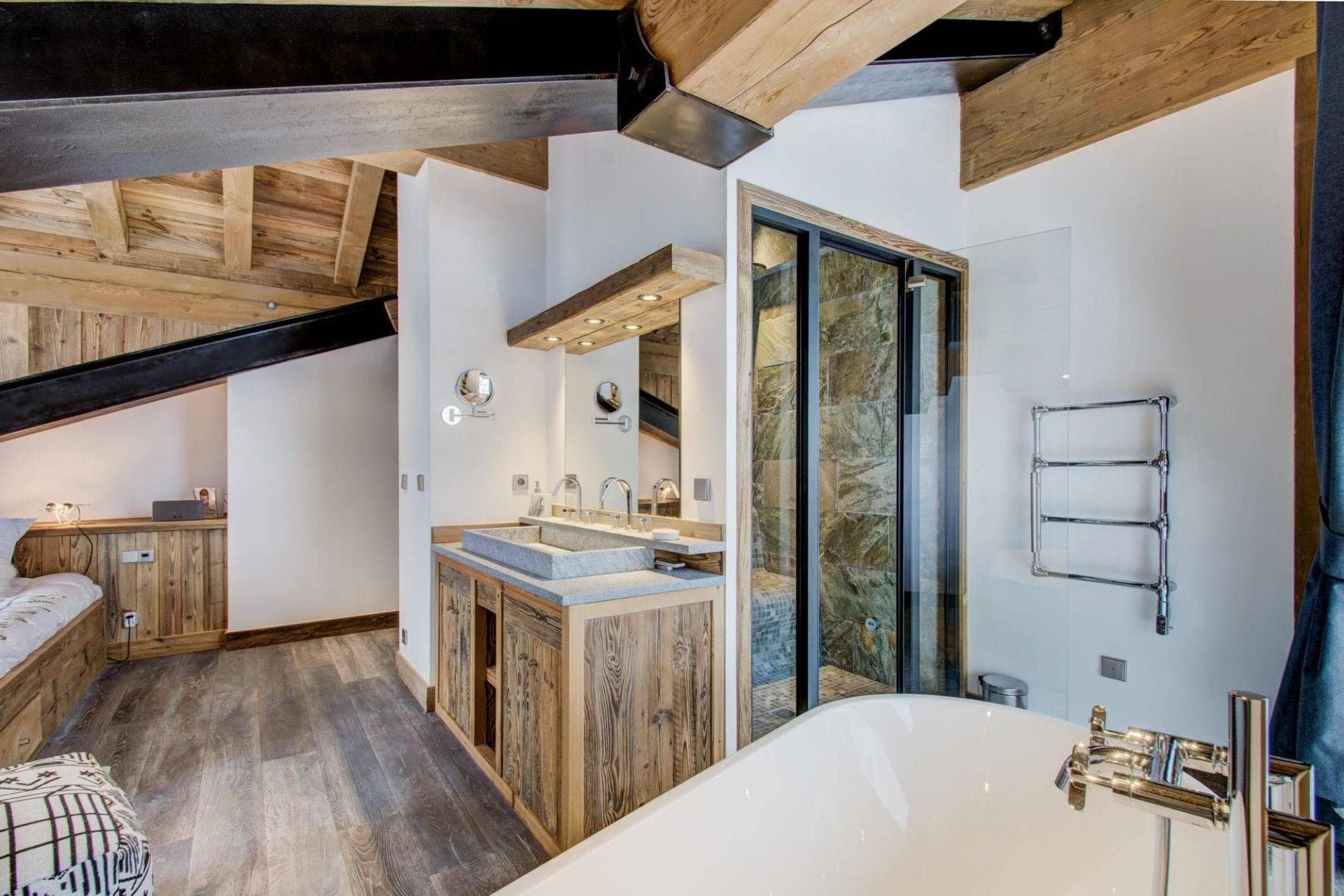 En suite bathroom with stone trough sink, walk-in shower, and heated towel rail