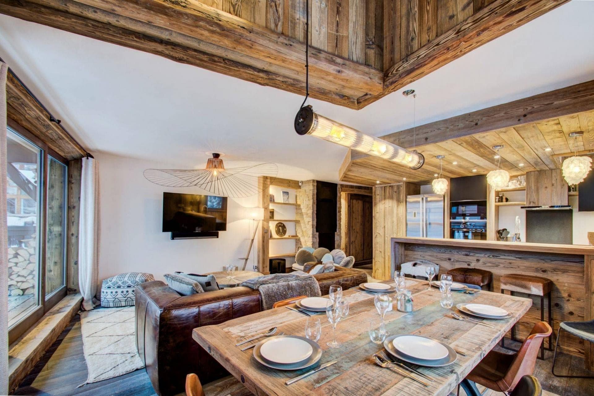 Open-plan living area featuring reclaimed wood ceilings and 8-person dining table