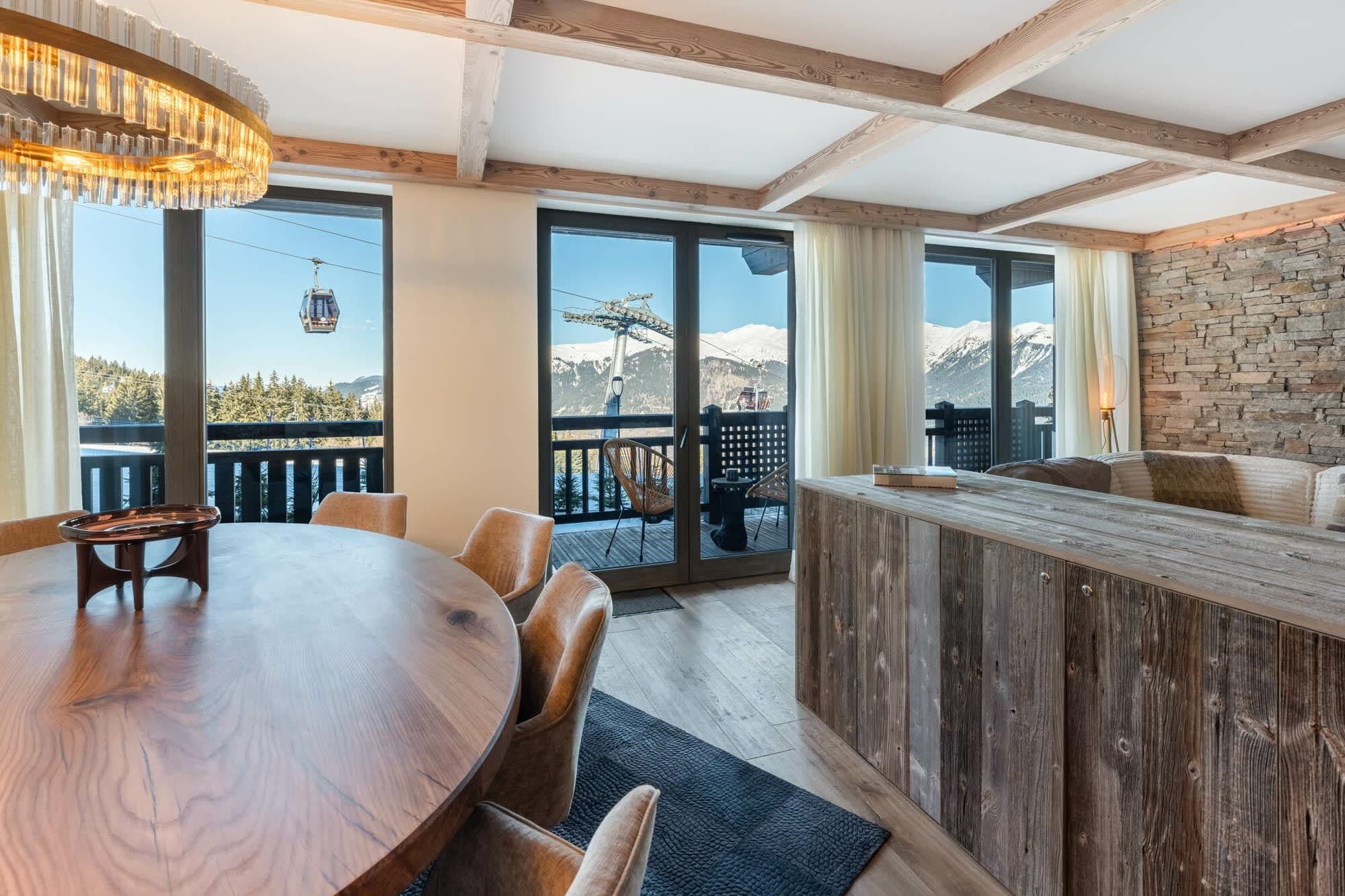 Open-plan dining area with balcony access and ski gondola views