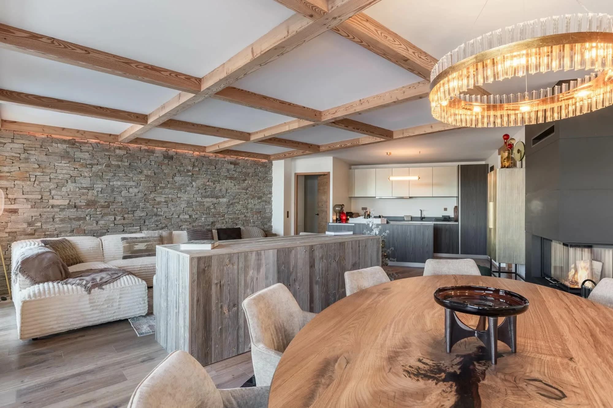 Open-plan lounge with timber beams and a wood fireplace