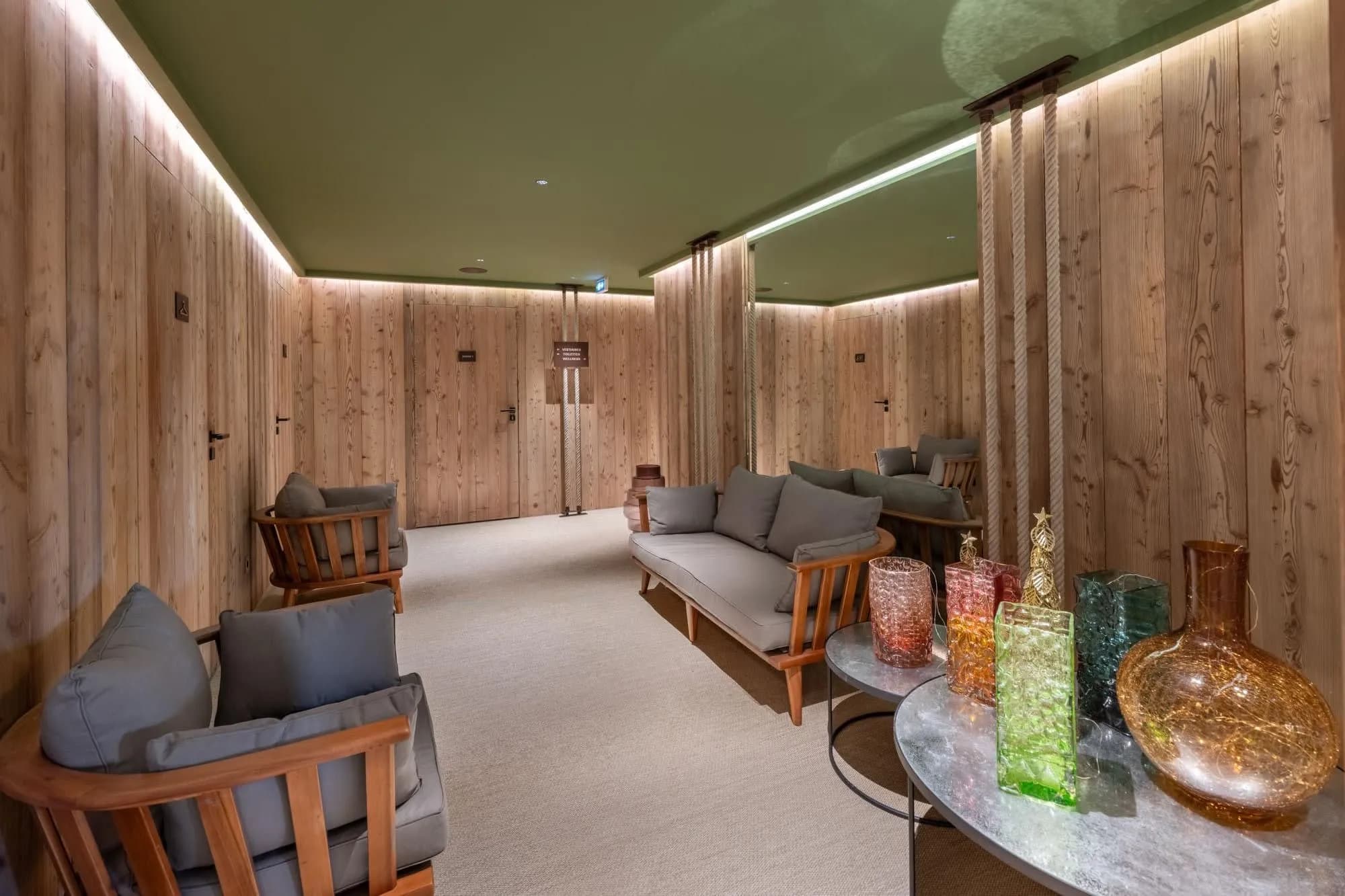 Shared lounge with timber walls and a hallway to the ski lockers