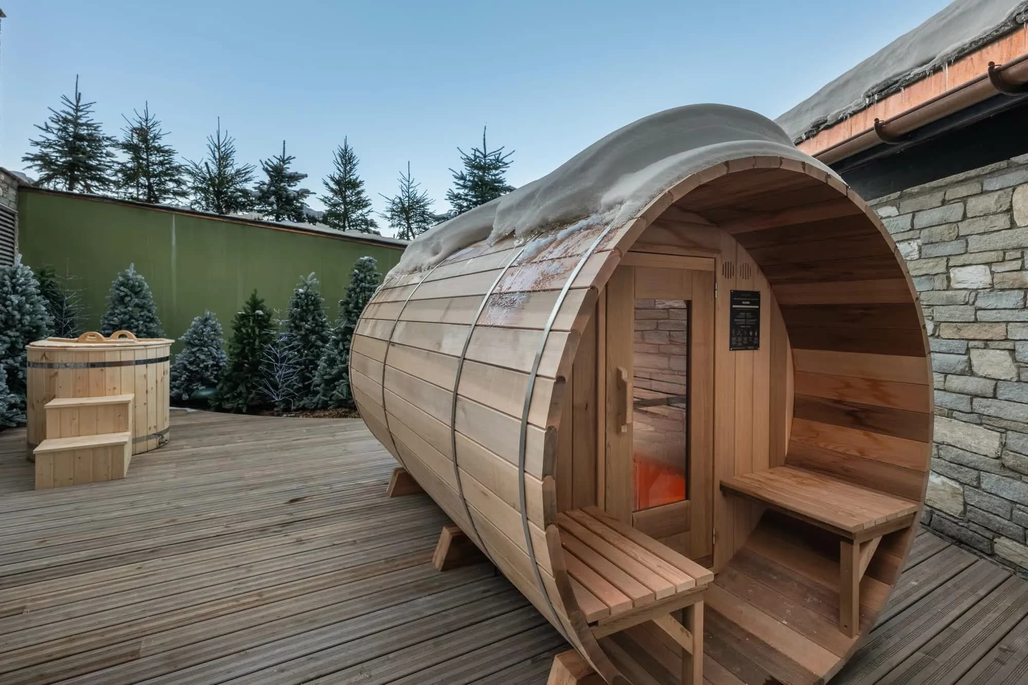 Outdoor barrel sauna and Nordic bath in the shared wellness area