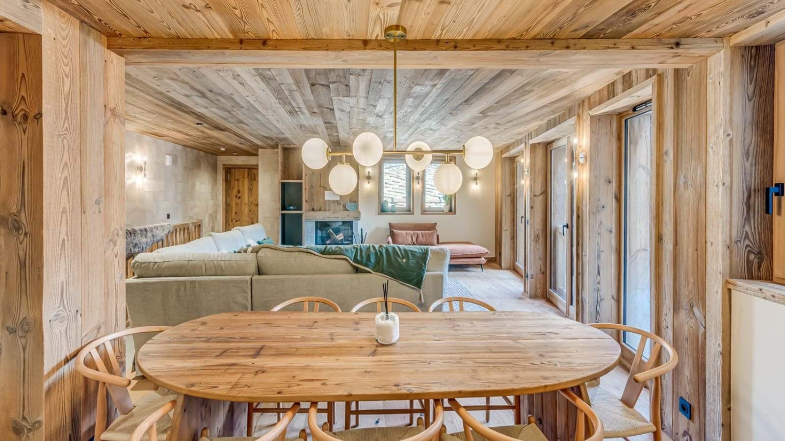 Open-plan dining area seating 8 with wood-paneled ceilings and integrated fireplace