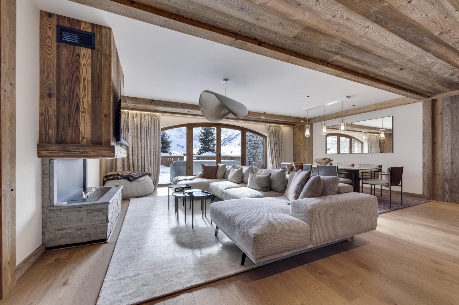 Open living area with gas fireplace, sectional seating, and mountain views