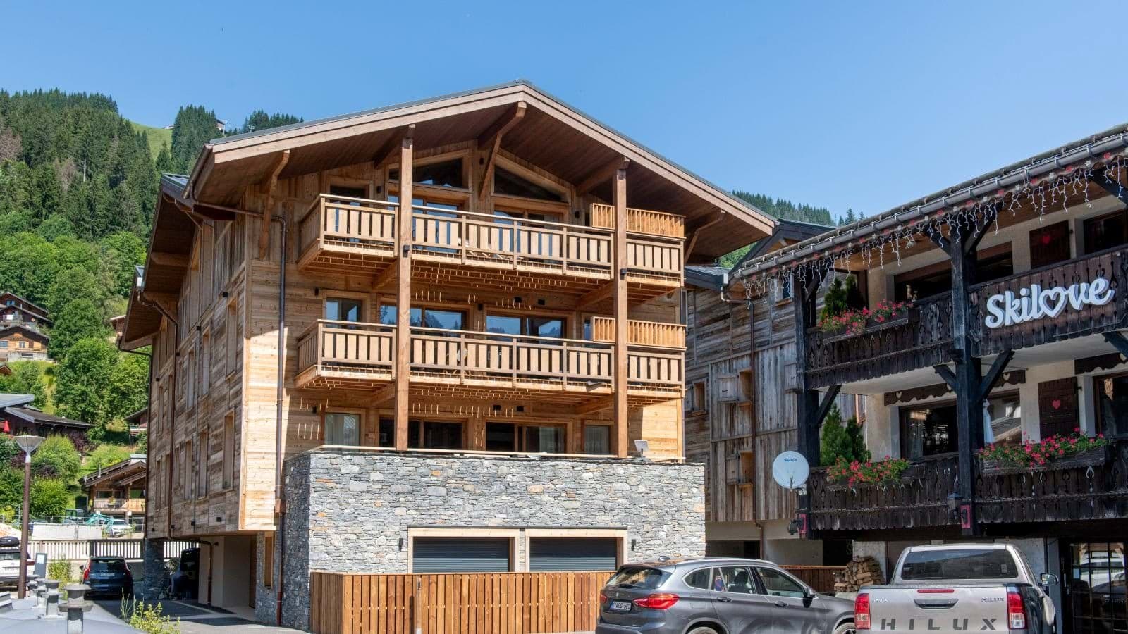 Chalet exterior with three private balconies and ground-floor garage