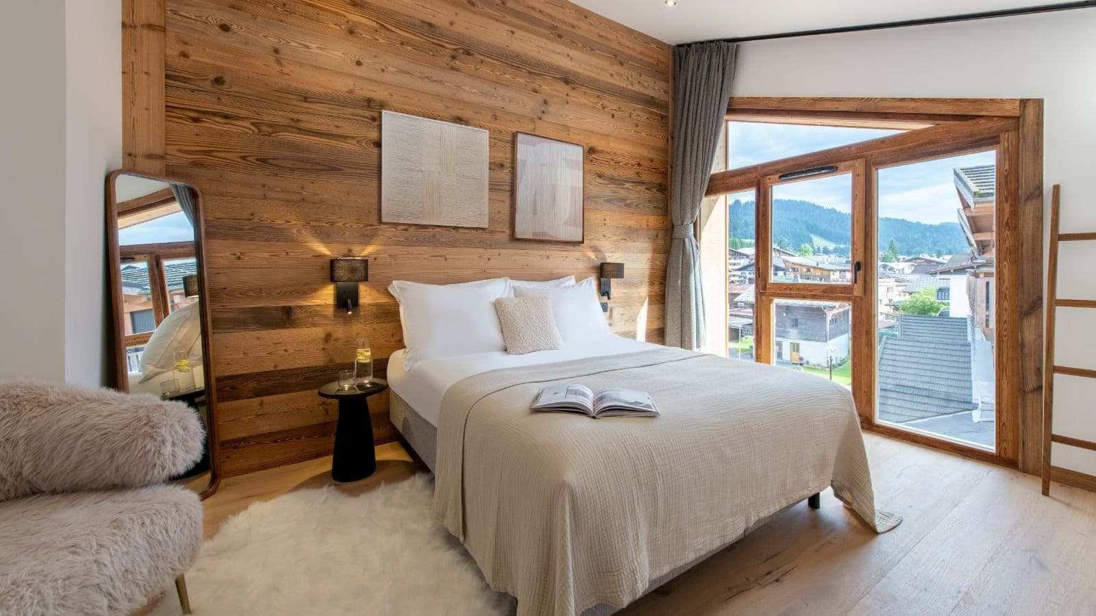 Primary bedroom with king bed and floor-to-ceiling village views