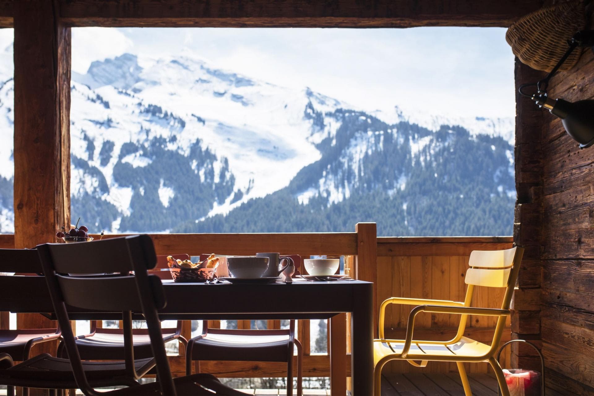 Covered balcony with dining table and panoramic Alpine views