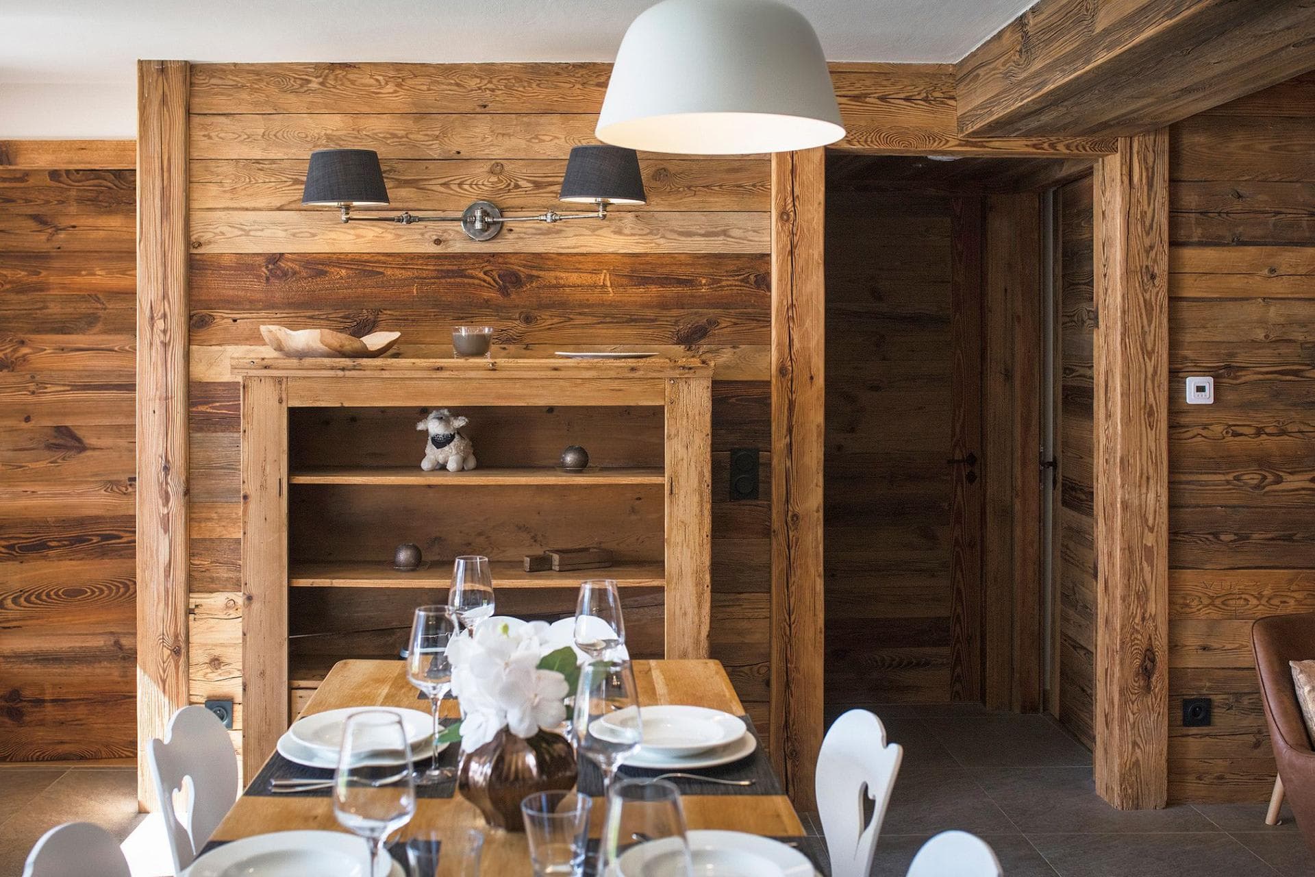 Dining area with reclaimed wood walls and heart-cutout chalet chairs