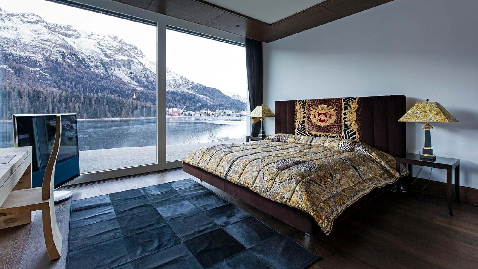 Primary bedroom with king bed and floor-to-ceiling lake and mountain views