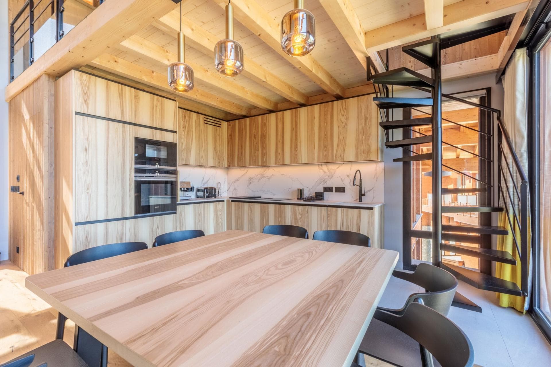 Kitchen and dining area with spiral staircase leading to loft level