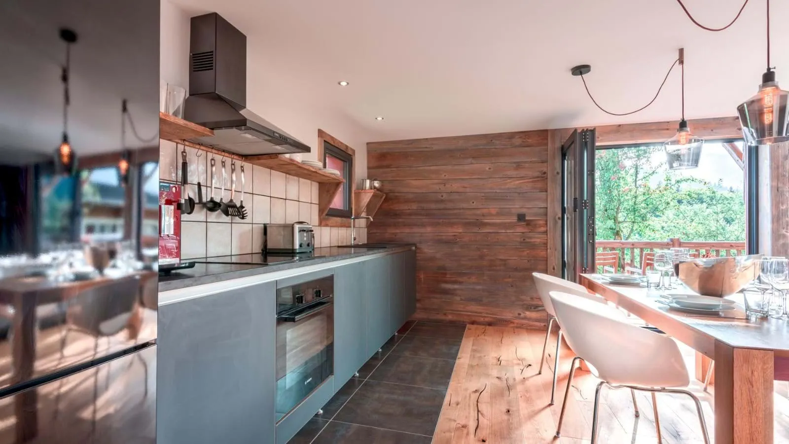 Open-plan kitchen and dining area with doors to the balcony
