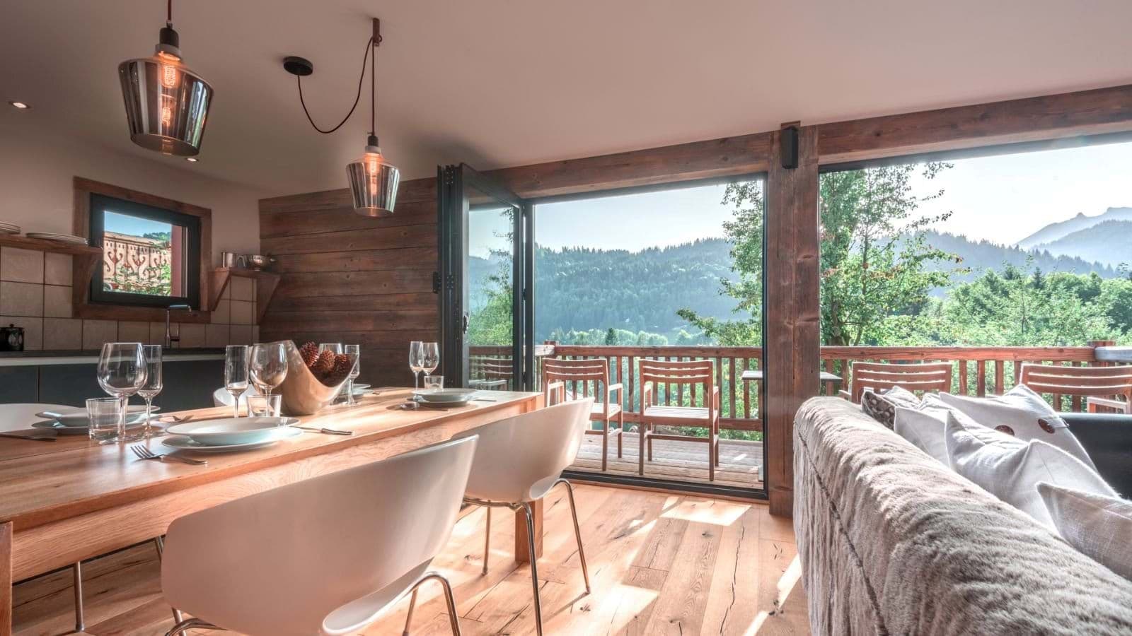Open-plan dining area with bi-fold doors leading to mountain-view deck