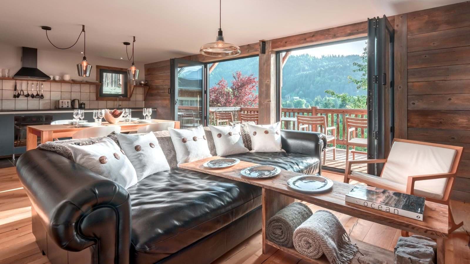 Open-plan living area with bi-fold doors to mountain-view balcony