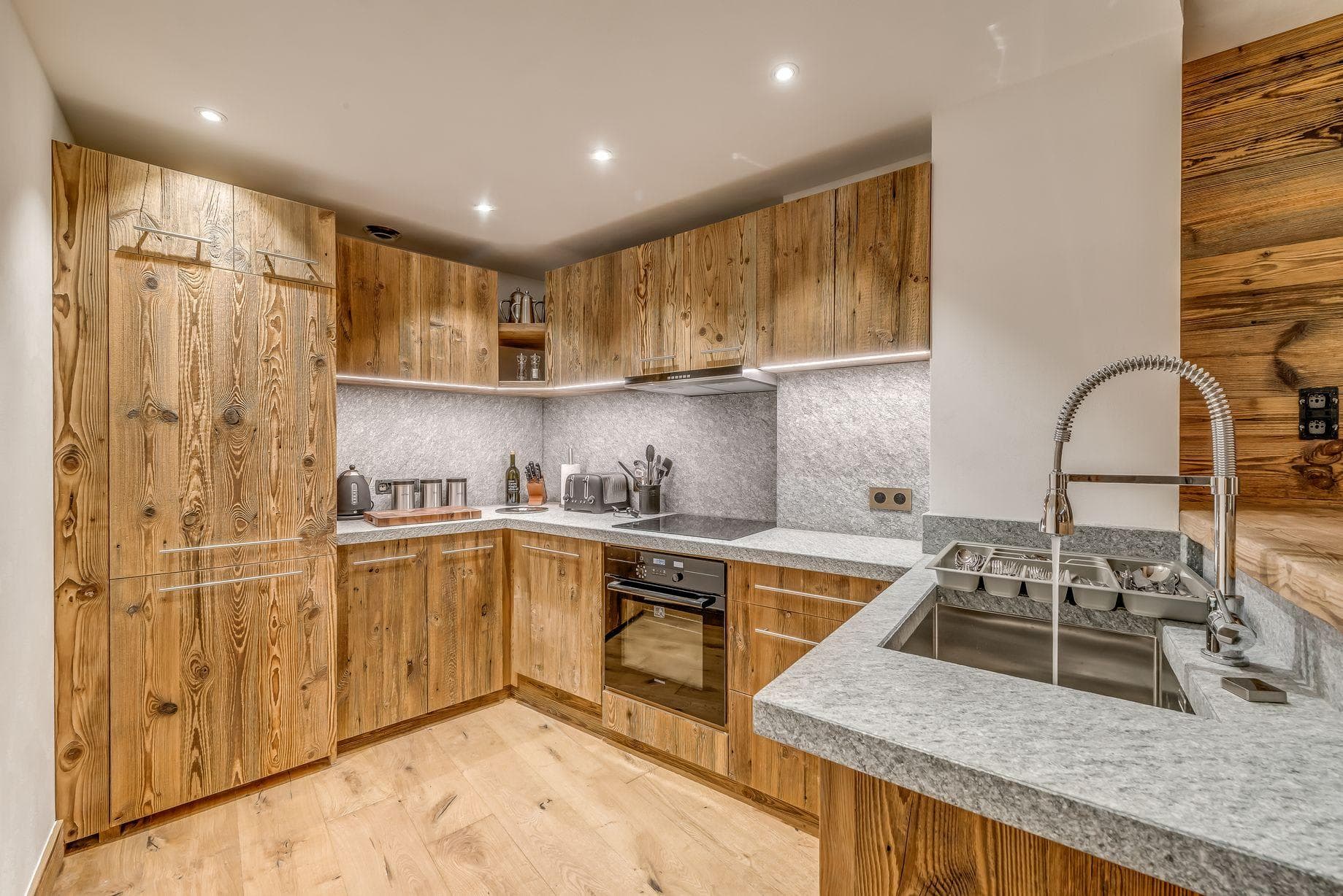 Kitchen with reclaimed wood cabinetry and integrated refrigerator