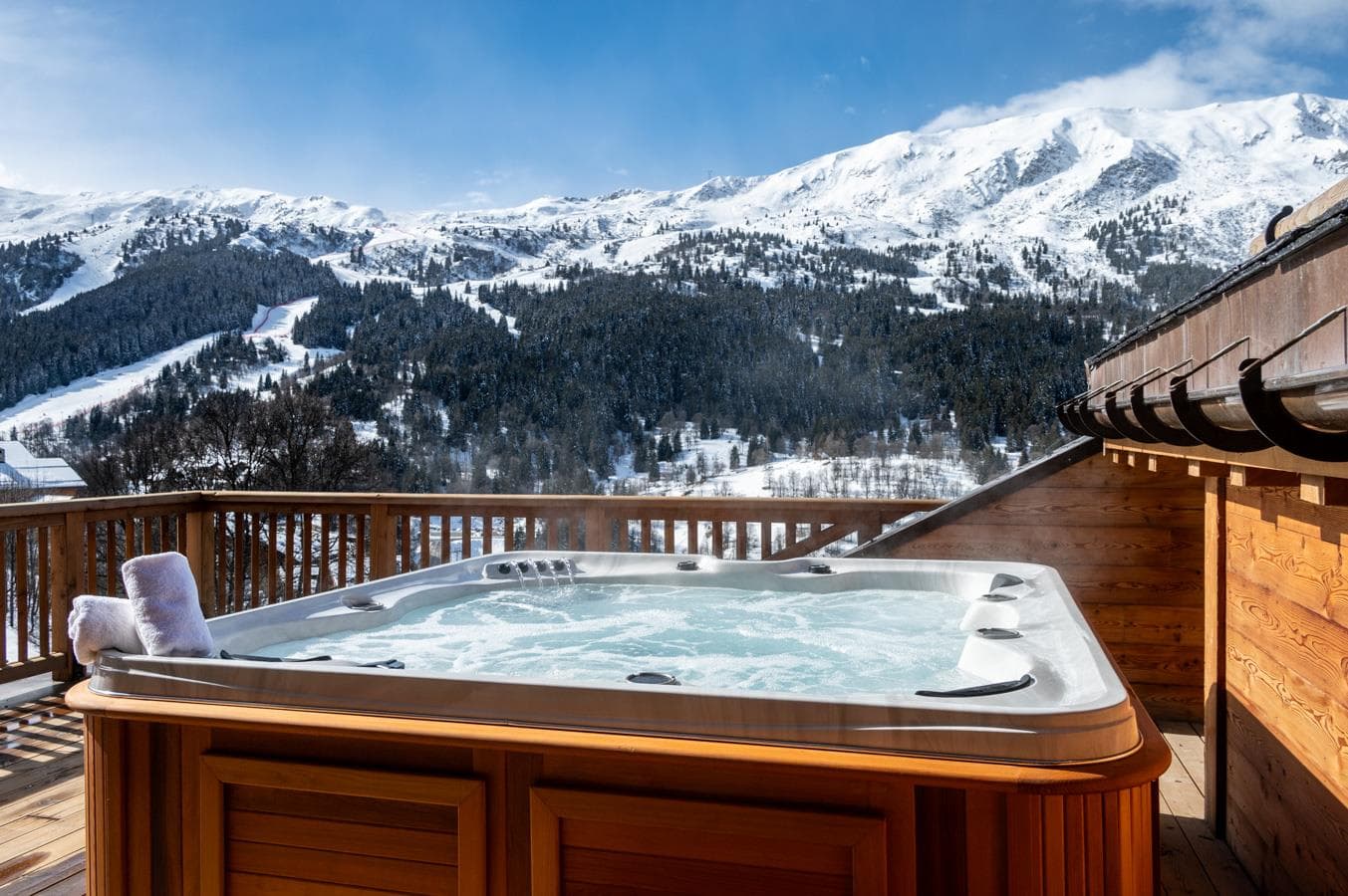 Outdoor hot tub with panoramic mountain and ski slope views