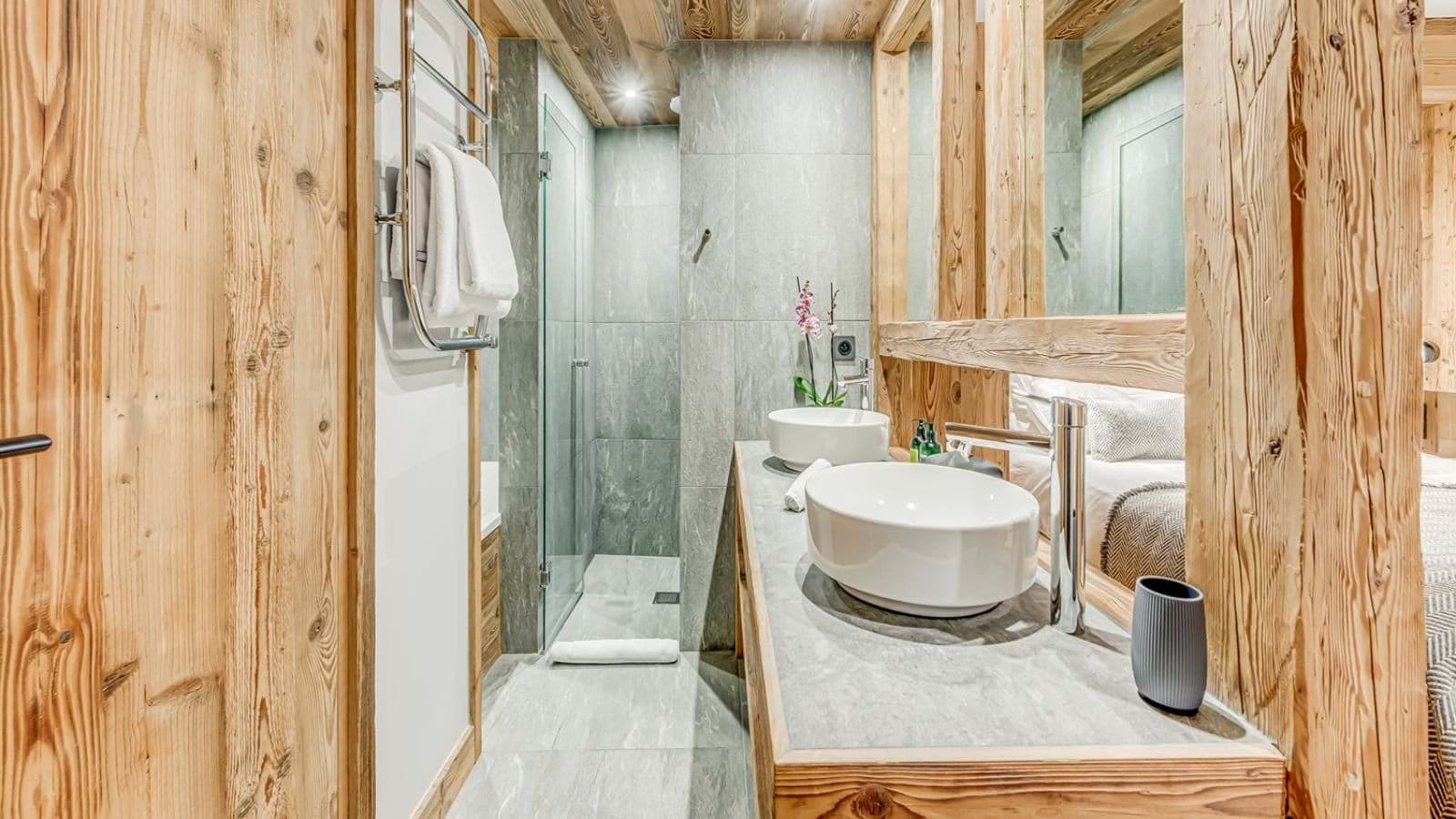 Bathroom with dual vessel sinks, heated towel rail, and walk-in shower