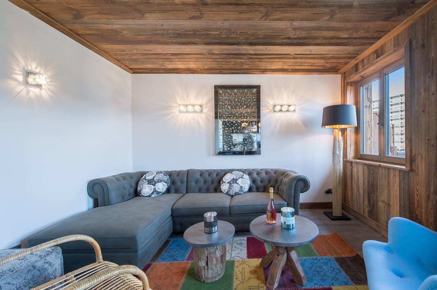 Living area with reclaimed wood ceiling and tufted sectional seating