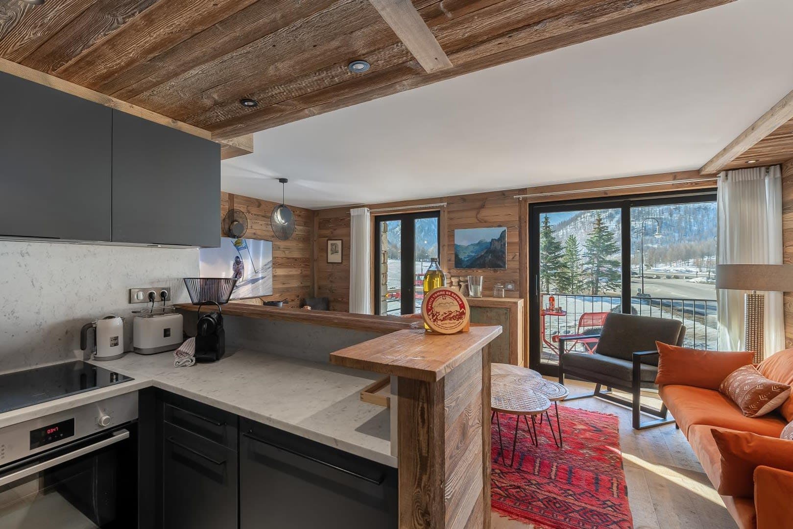 Open-plan kitchen and living area with balcony access and mountain views