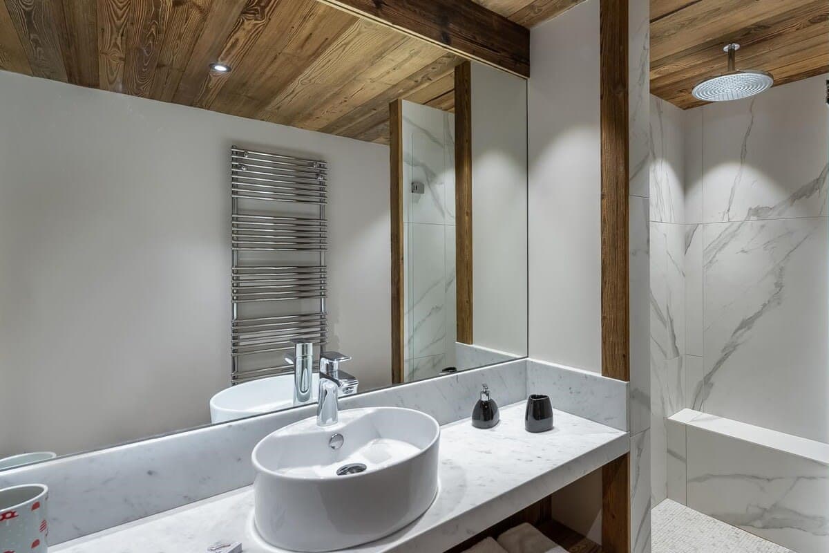 Bathroom with heated towel rail and rainfall shower featuring built-in bench
