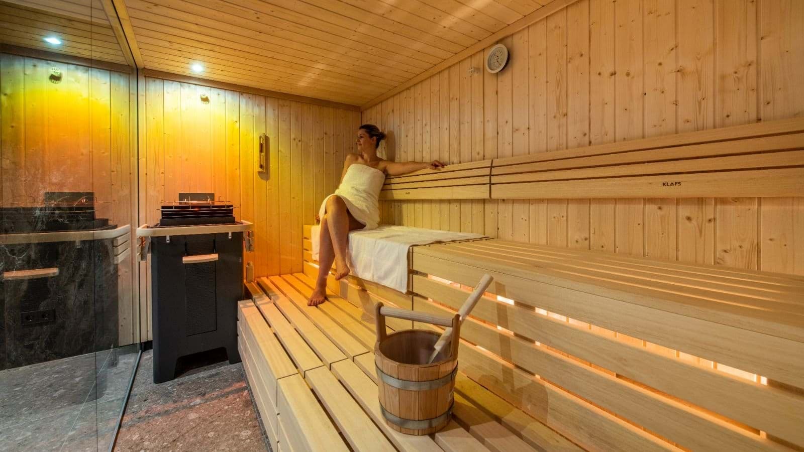 Private Klafs cedar sauna with tiered seating and electric heater