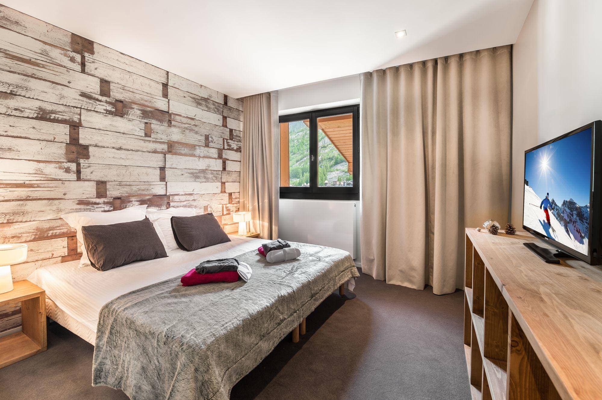 Guest bedroom with king bed and reclaimed wood feature wall