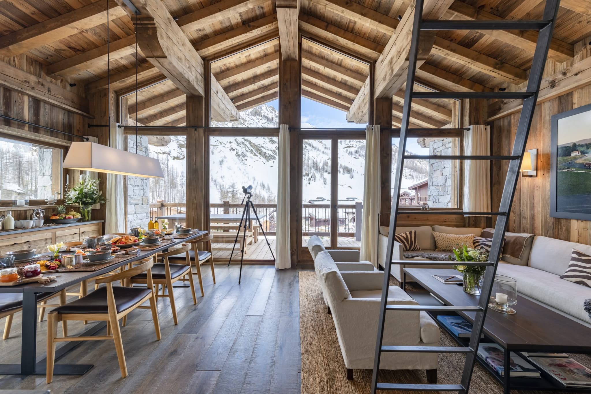 Open-plan living area with 10-person dining table and mountain-facing balcony