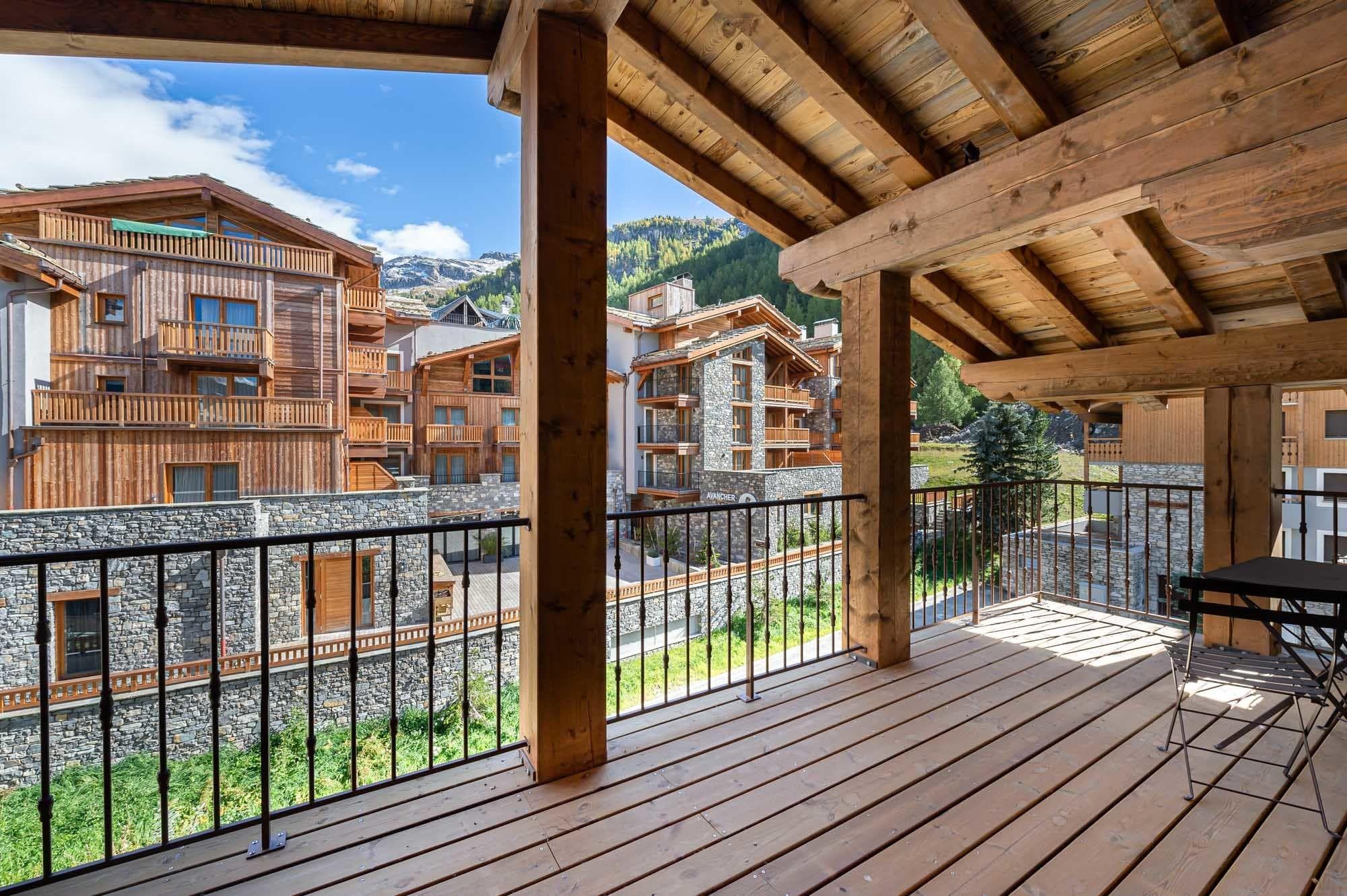 Covered timber balcony with bistro seating and alpine mountain views