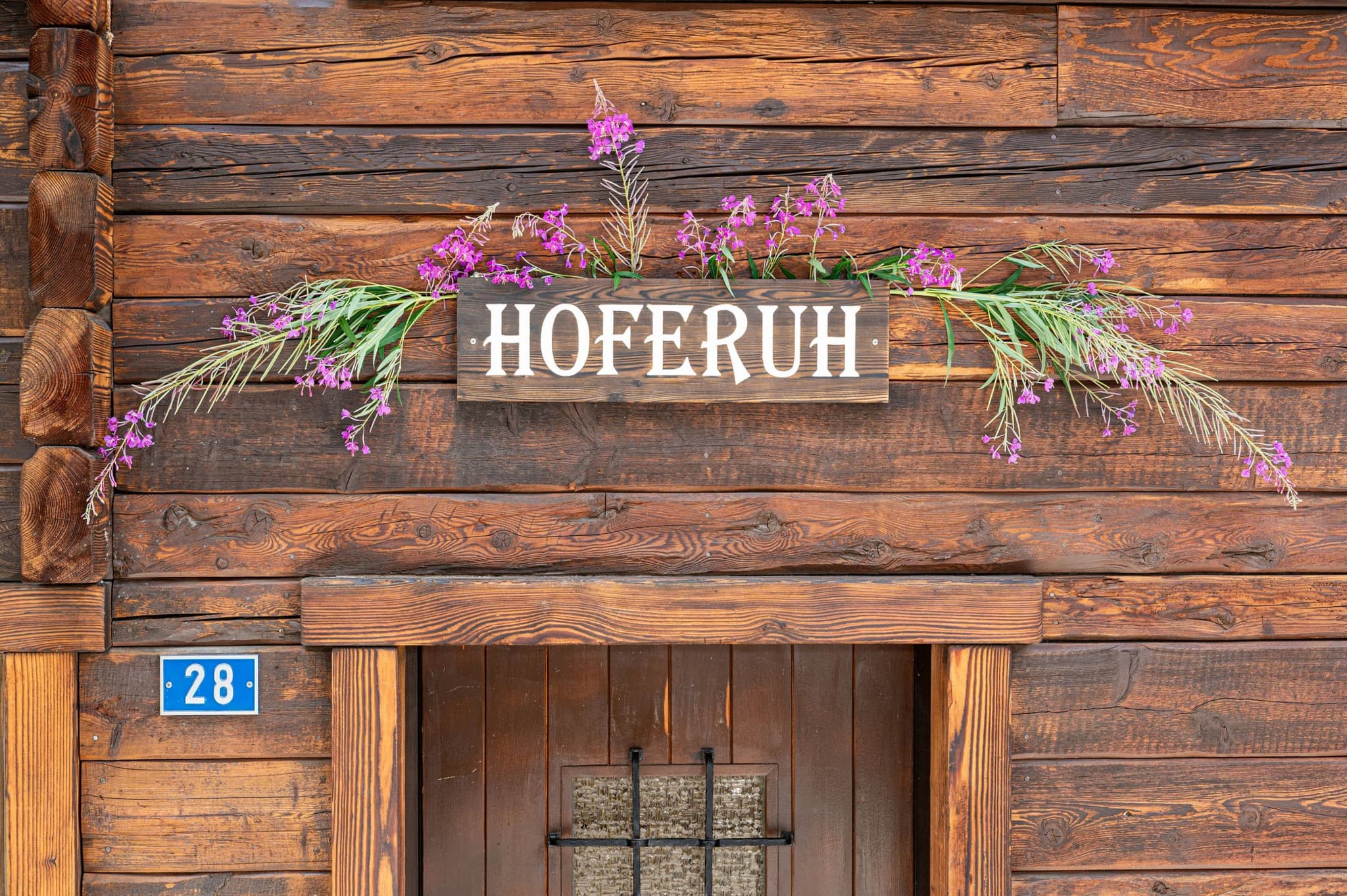 Chalet entrance featuring hand-carved signage and original dark-stained timber facade