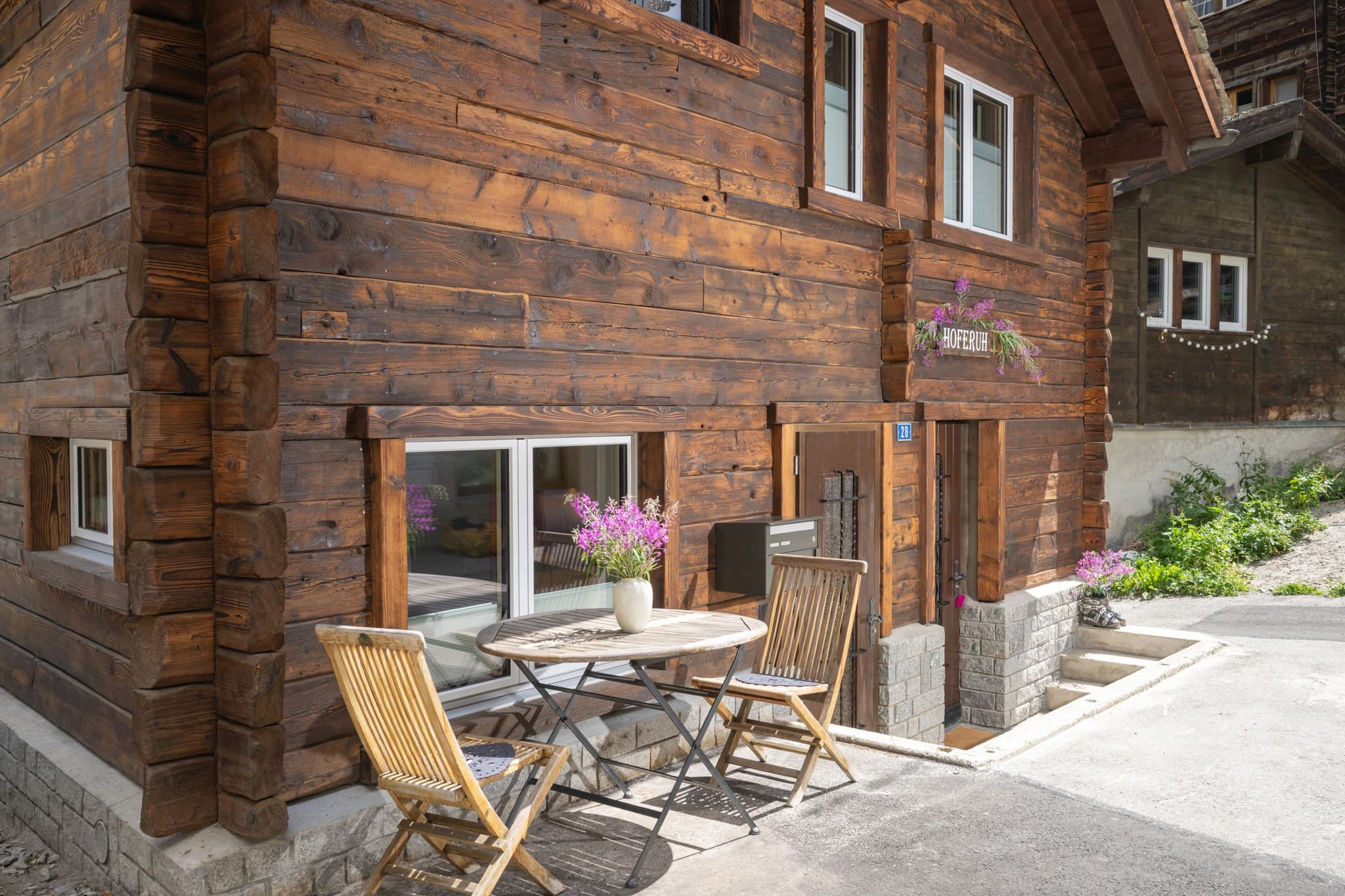 Chalet entrance with bistro seating and original timber log construction